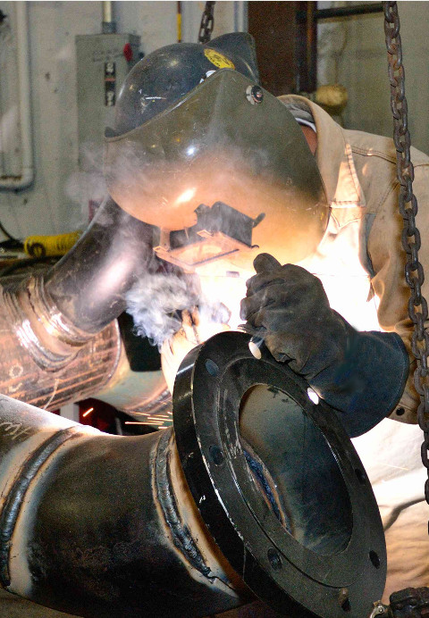 Employee welding a pipe