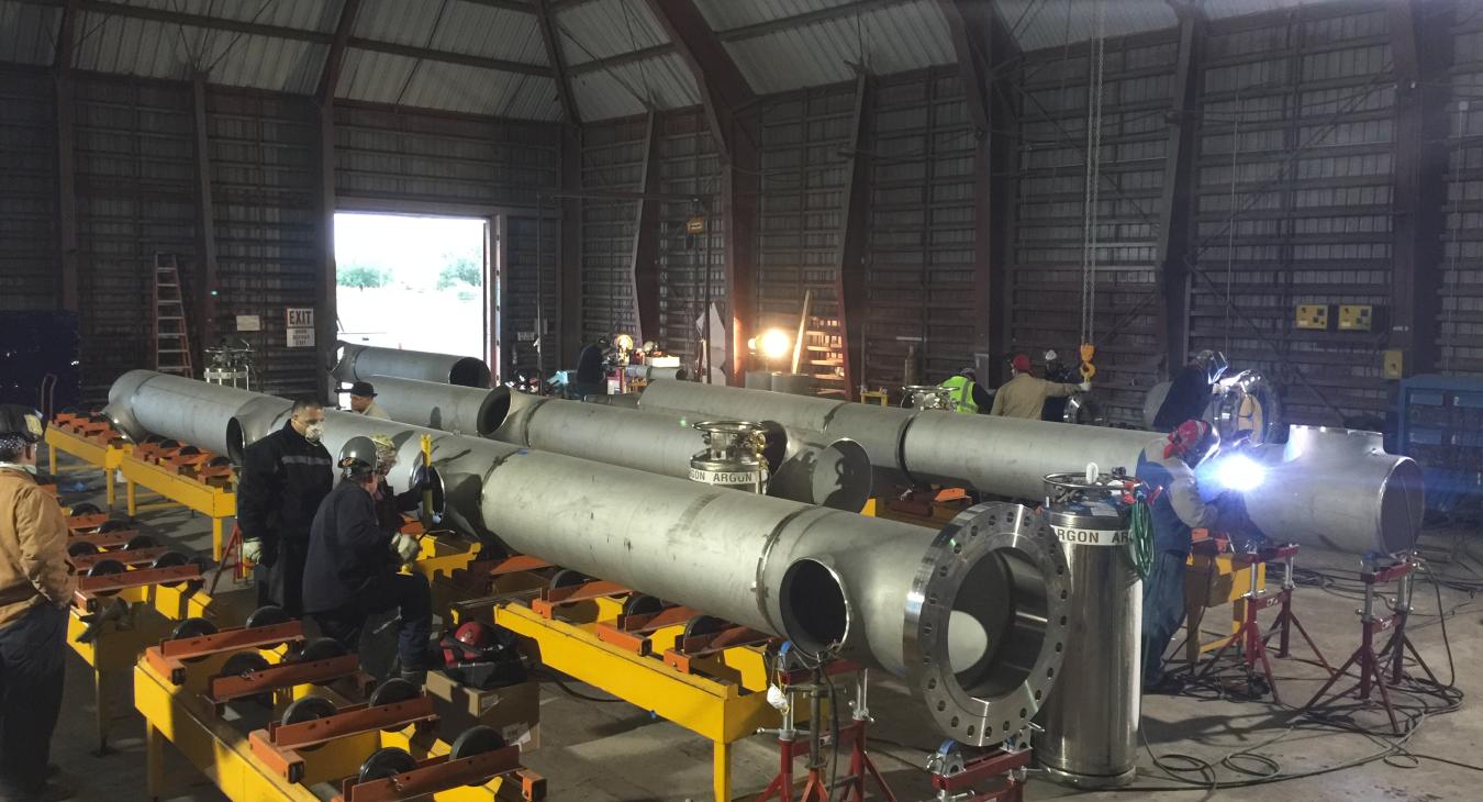 Stainless steel piping being assembled in warehouse