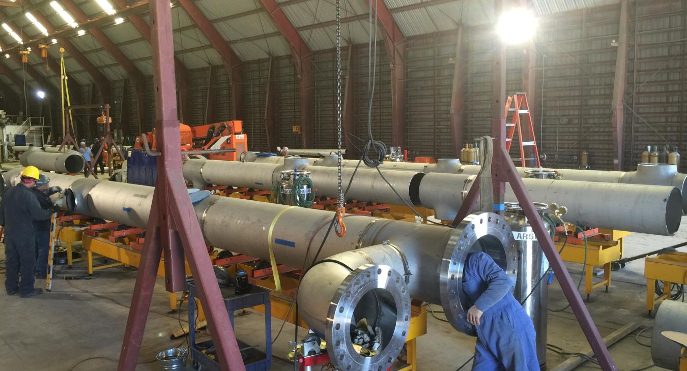 Stainless steel piping being assembled in warehouse