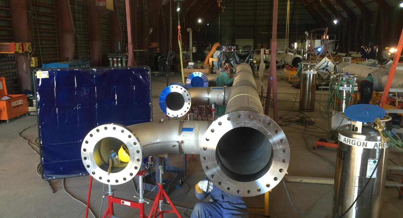 Stainless steel piping being assembled in warehouse